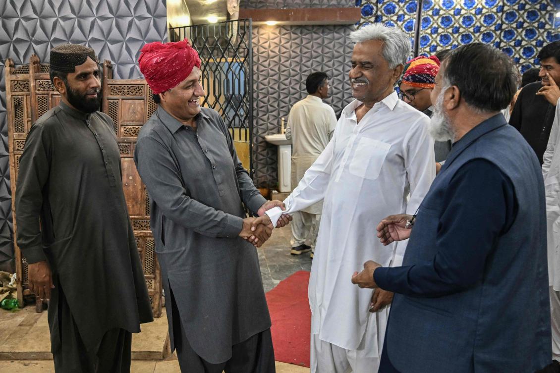 This photograph taken on February 27, 2026 shows Hindu social activist Partab Shivani (2L) receiving his guests for Iftar during the Islamic holy fasting month of Ramadan, at Mithi in the Tharparkar district of Sindh province. (AFP)