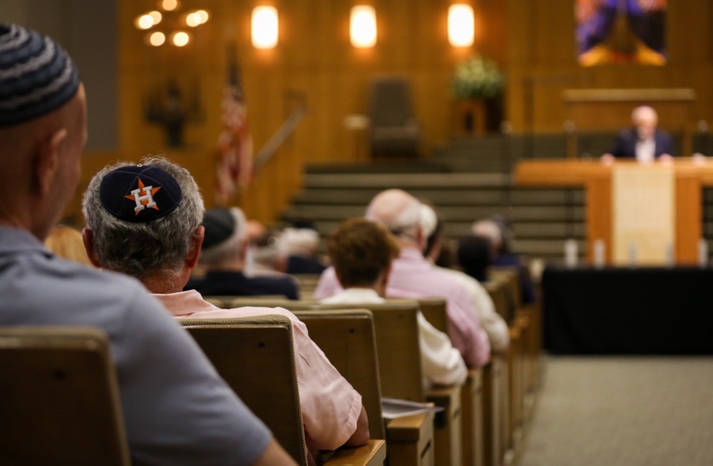 A man listens during a Yom HaShoah ceremony for Holocaust Remembrance Day, April 24, 2022, at Congregation Beth Israel in Houston. (Houston Chronicle via AP)