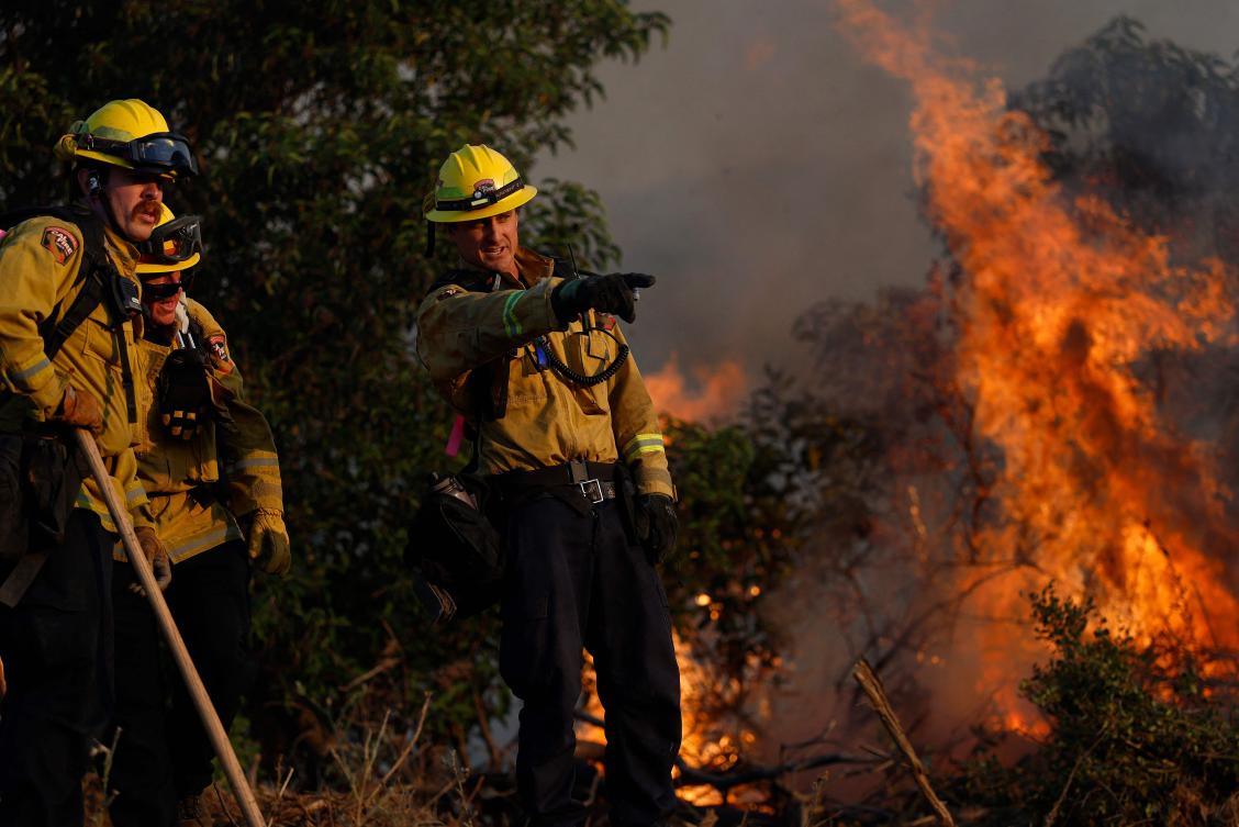Cal Fire firefighters battle the Sandy Fire as it burns through heavy brush on May 18, 2026 in Simi Valley, California. (AFP)