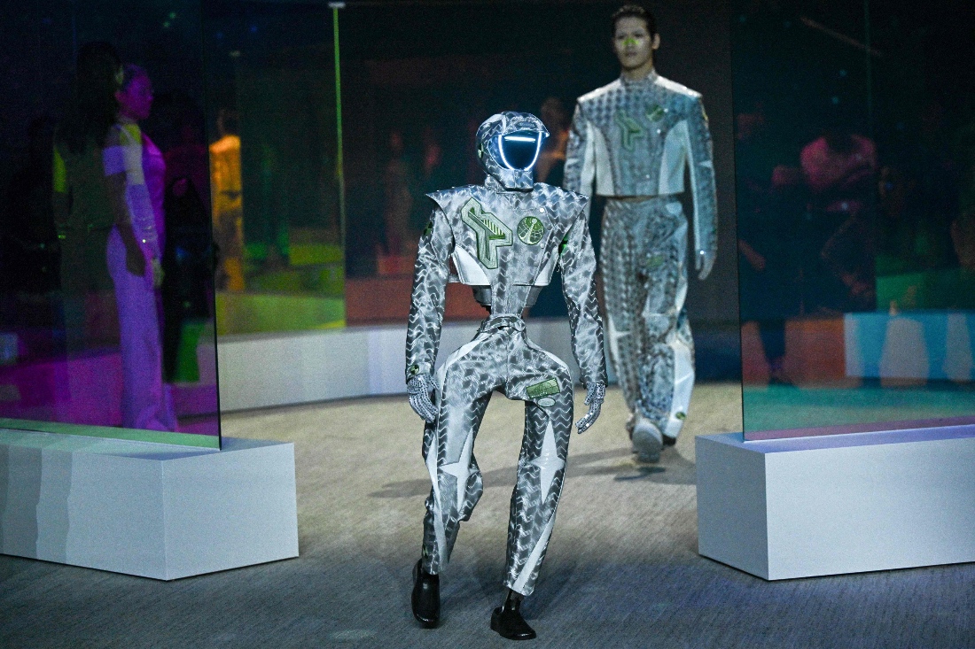 A humanoid robot and a model present creations at Galaxy Corporation's "Mach33: Physical AI Fashion Show" in Seoul, South Korea. (AFP)