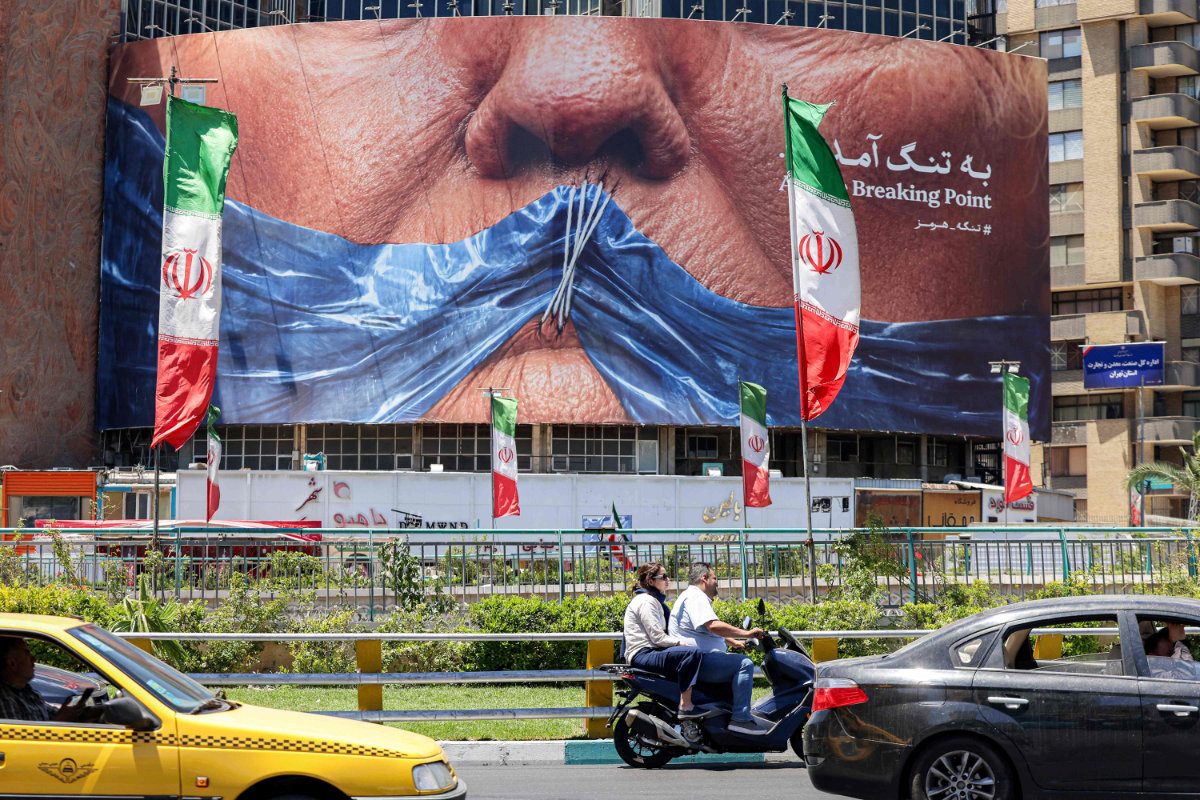A political billboard featuring Trump and Hormuz Strait is seen along Valiasr Square in Tehran on May 26, 2026. (AFP)