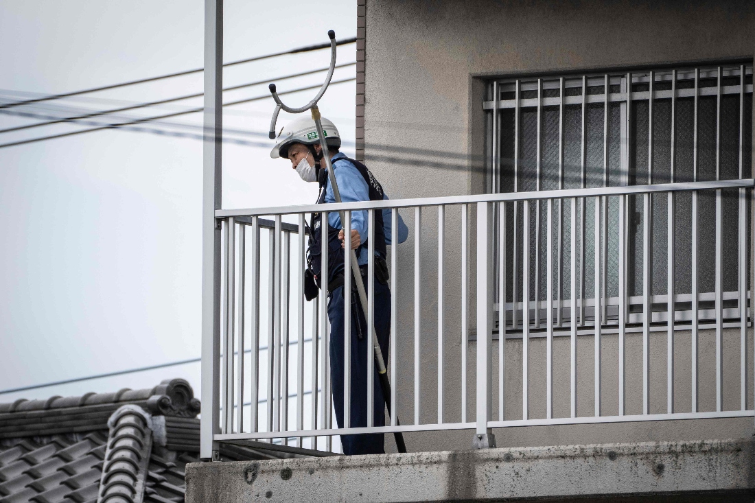 A police officer holding animal capture equipment looks for a wild bear during a widescale search for the animal in Utsunomiya, Japan. (AFP)