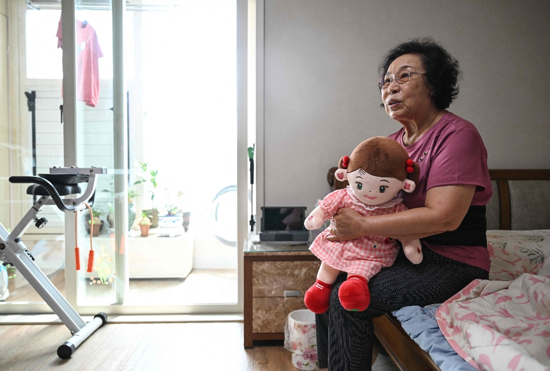 Bang Chun-ja, a South Korean elderly woman living alone, holding Hyodol, an AI-powered healthcare doll designed for elderly people at her home in Yongin, South Korea. (AFP)
