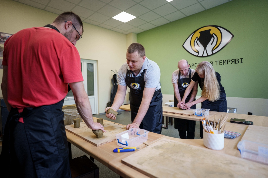 Ivan Shostak, center, a blind Ukrainian war veteran trains his comrade to make a clay plate during a pottery workshop at a rehabilitation center in Vinnytsia, Ukraine. (AP)