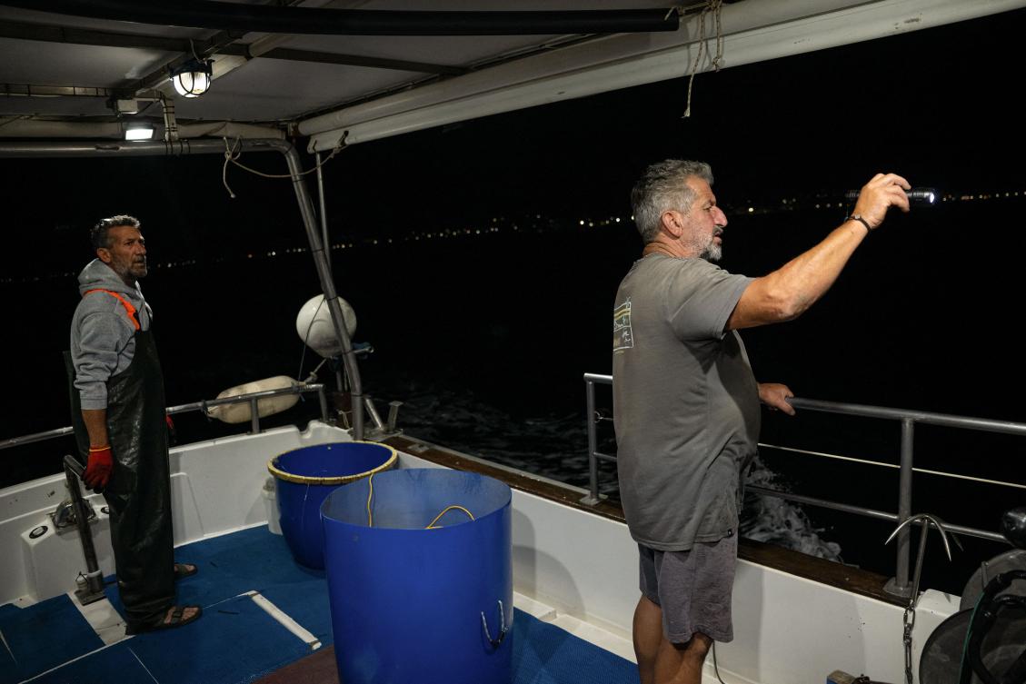 Fishermen Kostis Zevelekakis, left, and Michalis Zevelekakis fish on their boat near the port of Ierapetra, on the island of Crete on June 3, 2026. (AFP)