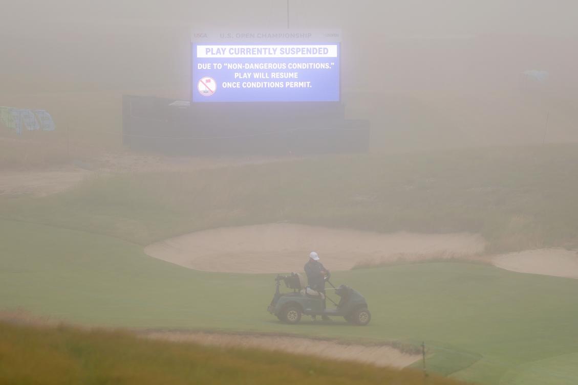 A general view of a video board displaying a message that play has been suspended due to limited visibility on the course during the first round of the 126th US OPEN at Shinnecock Hills Golf Club on Jun. 18, 2026 in Southampton, New York. (AFP)