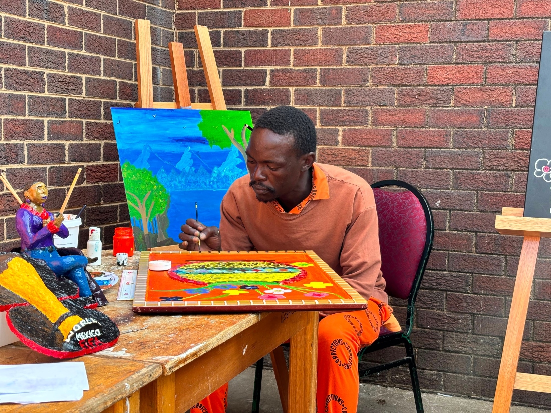 Lebohang Molefi paints during an exhibition of inmates' artworks at the Leeuwkop Correctional Centre in Johannesburg, South Africa. (AP)