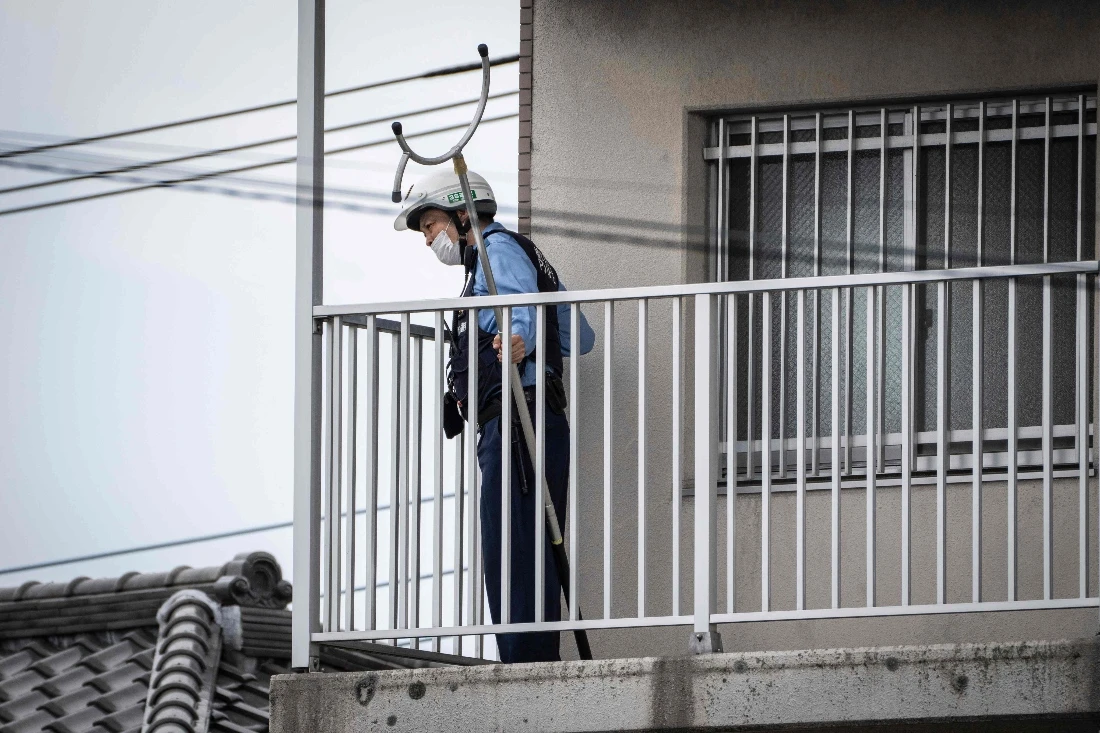 A police officer holding animal capture equipment looks for a wild bear during a widescale search for the animal in Utsunomiya, Japan. (AFP)