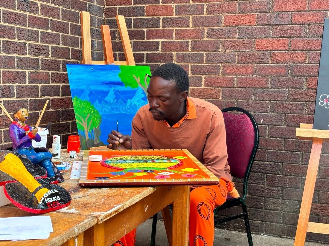 Lebohang Molefi paints during an exhibition of inmates' artworks at the Leeuwkop Correctional Centre in Johannesburg, South Africa. (AP)
