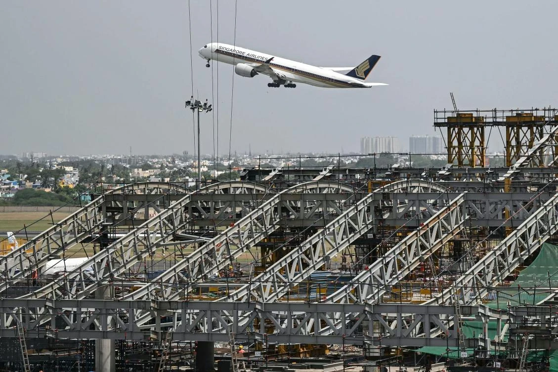 A Singapore Airlines passenger aircraft takes off near the under-construction new terminus at the Chennai International Airport on July 16, 2026. (Photo by R. Satish BABU / AFP)
