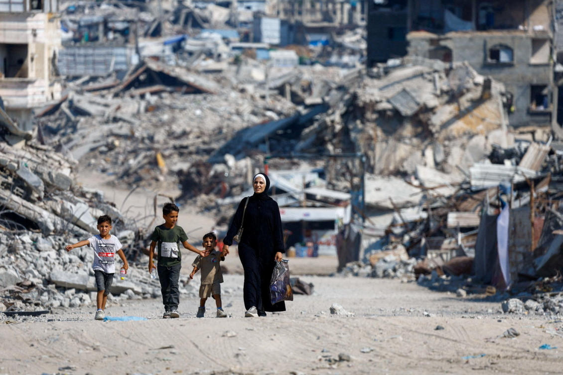 Palestinians walk past the rubble of residential buildings destroyed during the war in Gaza City, August 15, 2026. (Reuters)