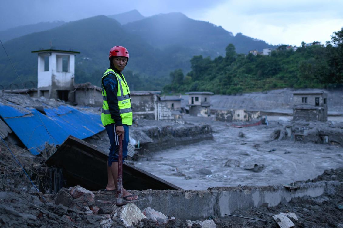 Above, a disaster rescue personnel looks on at the site of damaged buildings in the aftermath of flash floods at Trishuli Bazar in Nepal’s Nuwakot district on Aug. 29, 2026. (AFP)