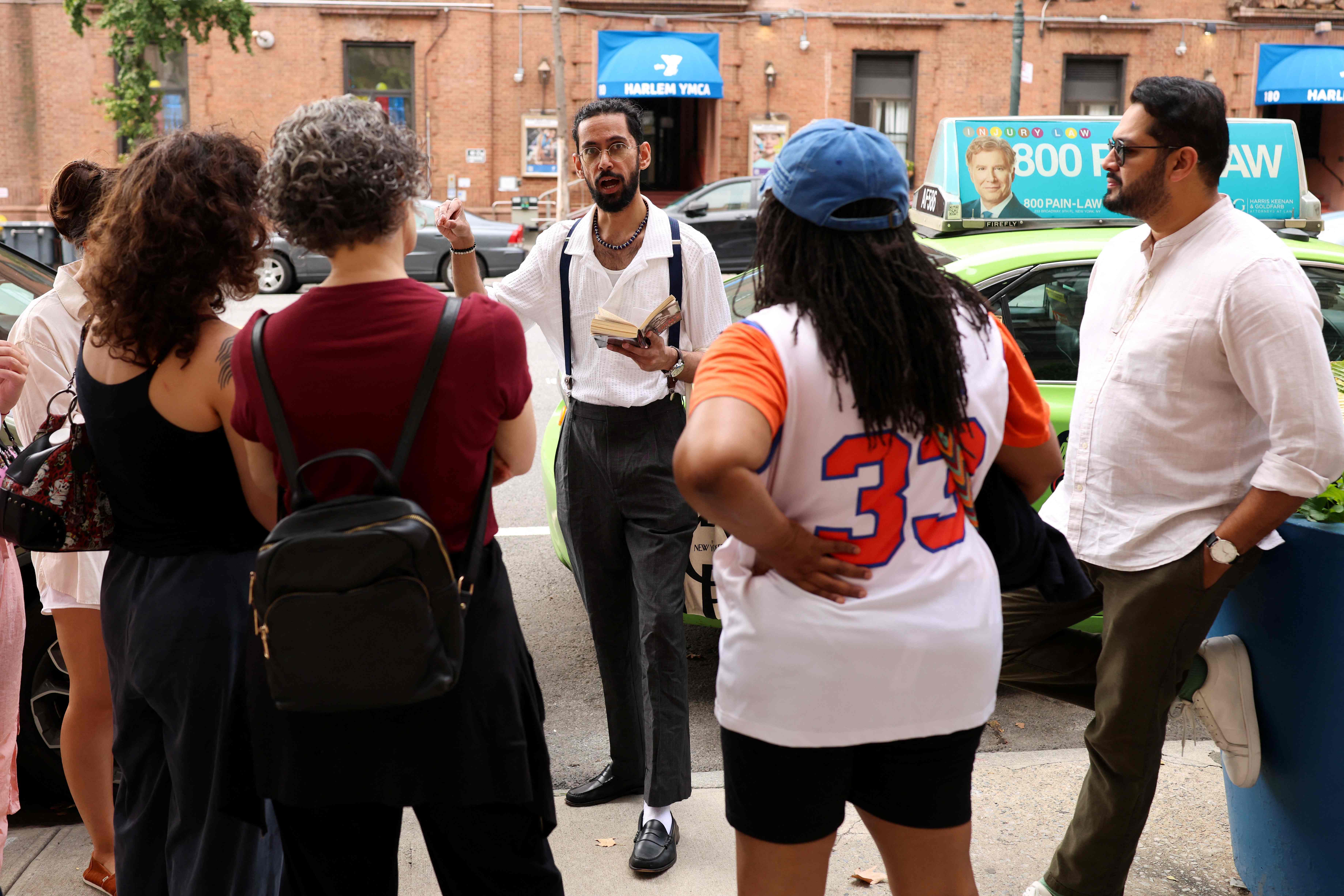 Asad Dandia (center) leads a guided tour on Malcolm X in Harlem, New York, on August 22, 2026. (AFP)
