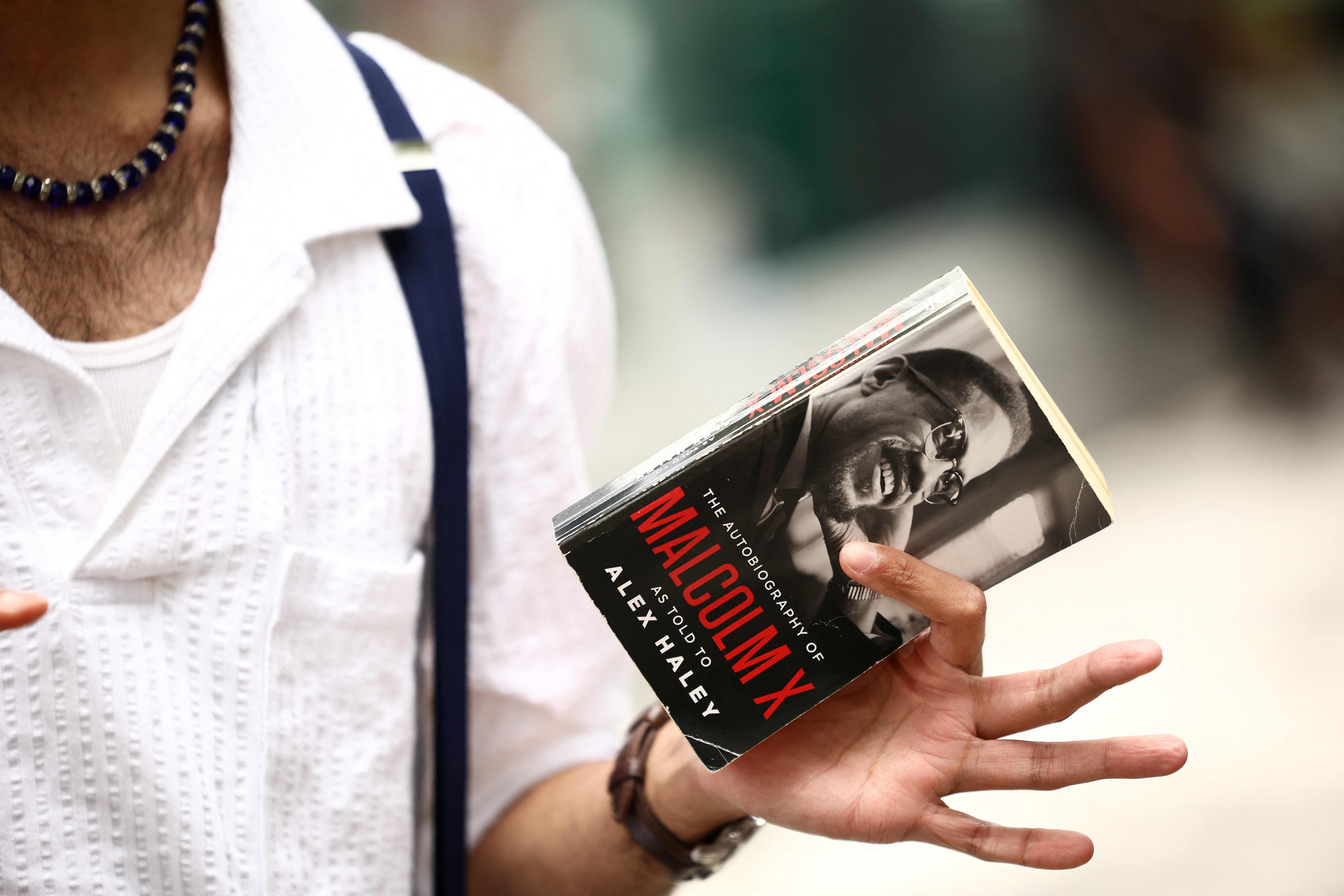Asad Dandia conducts a guided tour about Malcolm X in the Harlem area of New York on August 22, 2026. (AFP)