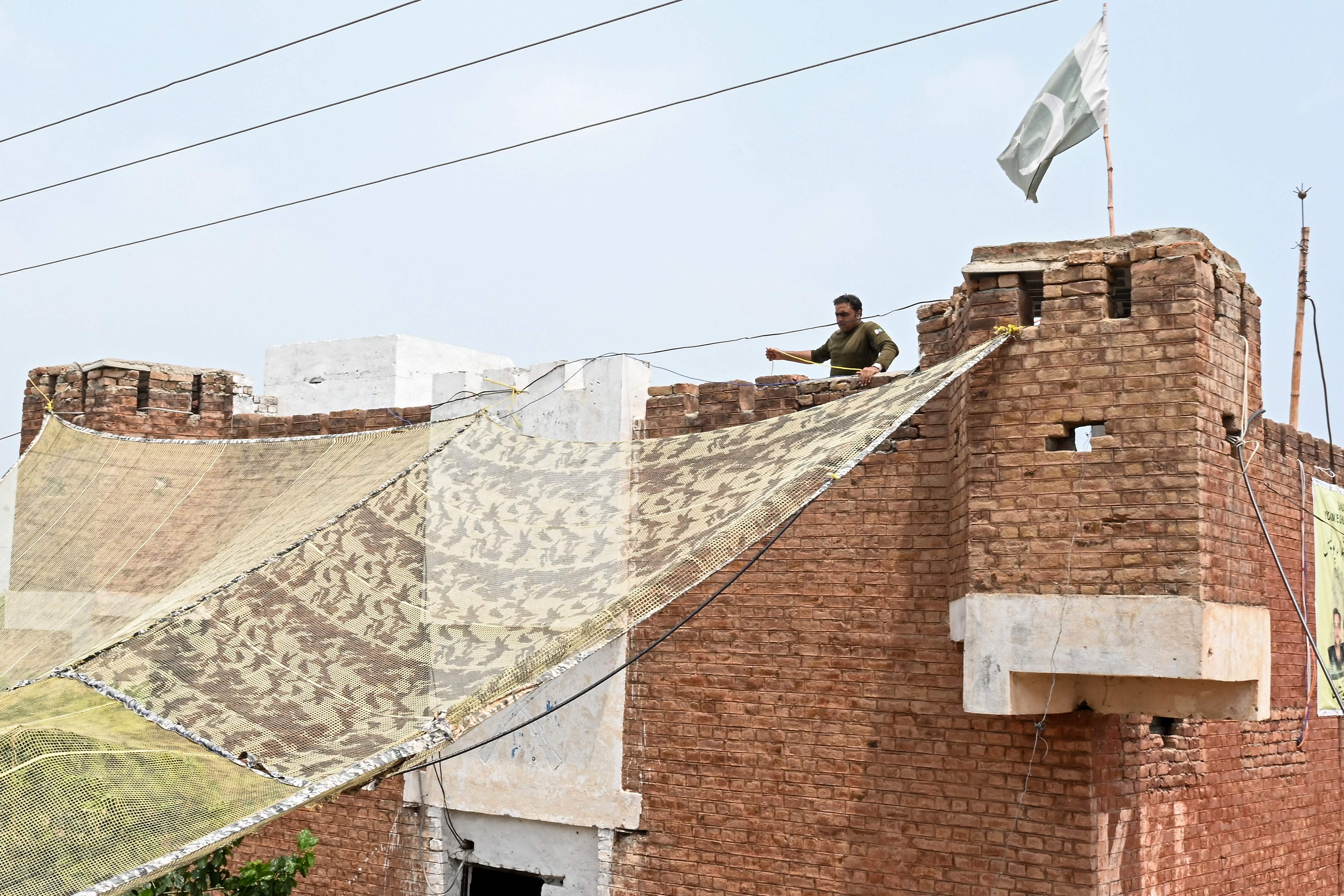 This photograph, taken on August 4, 2026, shows security personnel fortifying a police post with Ukraine-style mesh barriers in Bara, Khyber Pakhtunkhwa, Pakistan. (AFP)