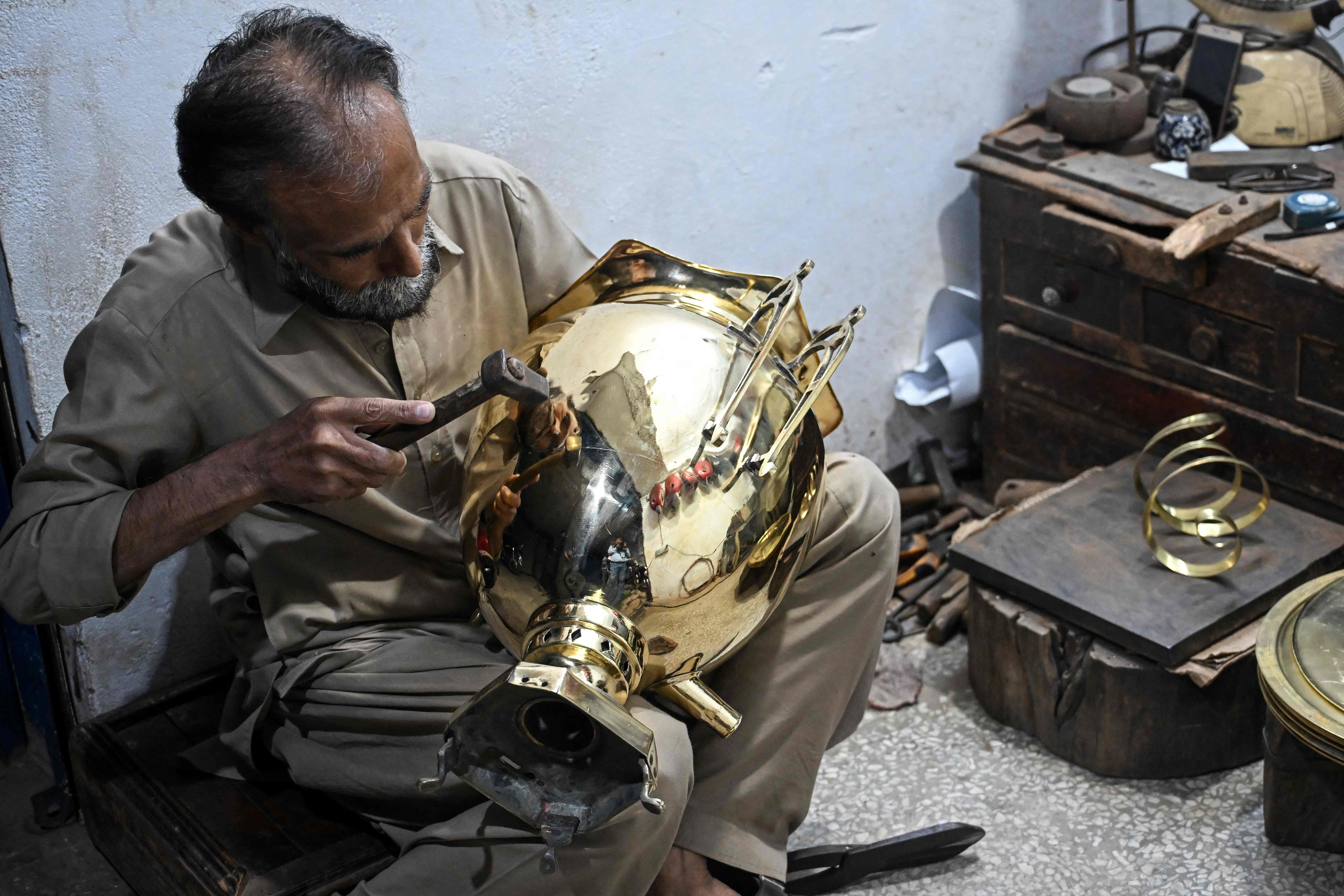 Antique dealer Shakeel Ahmed works on an artefact at his restoration workshop in Rawalpindi on October 20, 2026. (AFP)