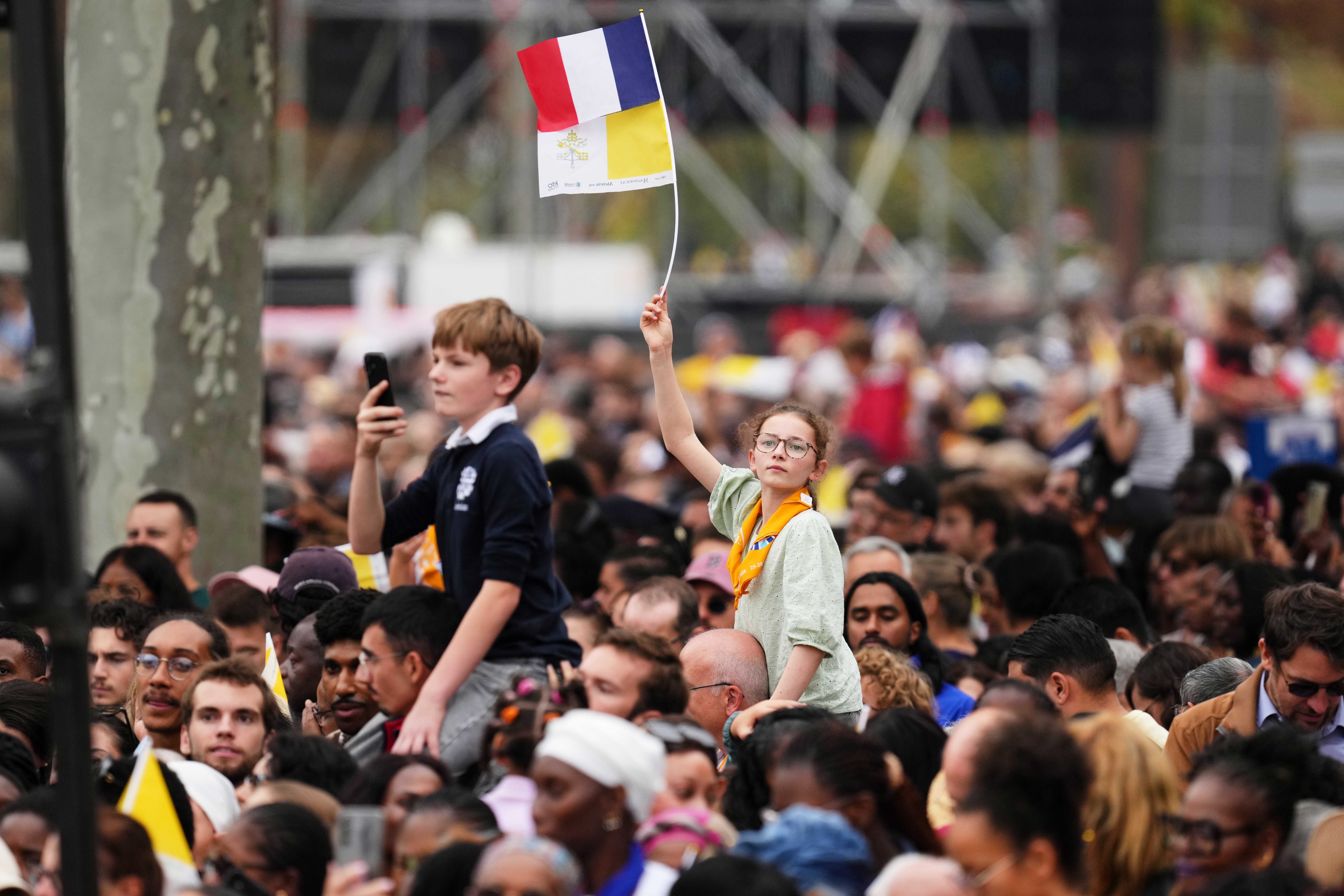 People wait for the arrival of Pope Leo XIV to celebrate mass at Place de la Concorde, Paris, Saturday.