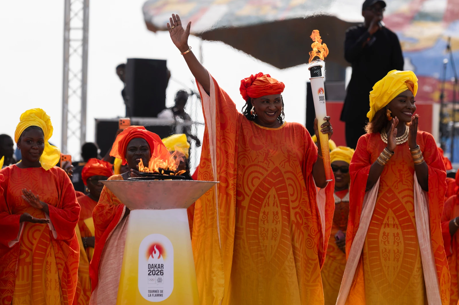 Senegalese basketball legend Mame Maty Mbengue lights a torch from the cauldron during a ceremony ahead of the Dakar 2026 Youth Olympic Games, in Dakar, Senegal, Saturday, Sept. 12, 2026. (AP)