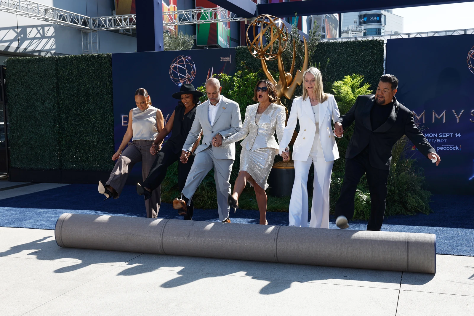 Executive producer Jeannae Rouzan-Clay, from left, executive producer Dionne Harmon, executive producer Jesse Collins, show host Mariska Hargitay, NBC EVP of live events Jen Neal, and Television Academy chair Chris Abrego roll out the blue carpet during a press preview for the 78th Primetime Emmy Awards on Thursday, Sept. 10, 2026, in Los Angeles. (Photo by Caroline Brehman/Invision/AP) (AP Photo/Caroline Brehman)
