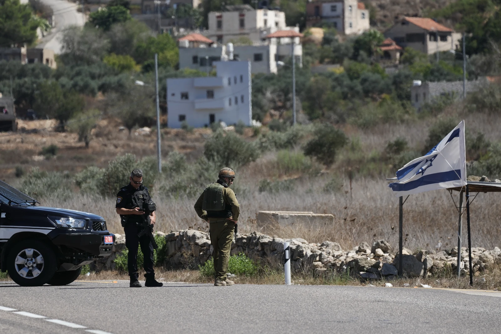 Israeli police officer and a soldier stand guard near the site of a shooting attack that, according to Israeli officials, killed one Israeli near the settlement of Neve Tzuf, north of the West Bank city of Ramallah, Sunday, Sept. 20, 2026. (AP)